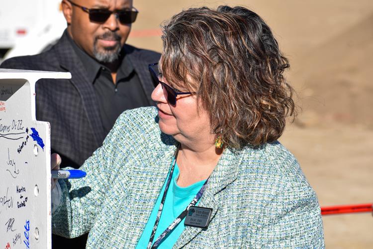 Becki Sims, VRHS assistant principal, adds her signature to the final steel beam during a topping-out event at VRHS Thursday, Feb. 1. 
